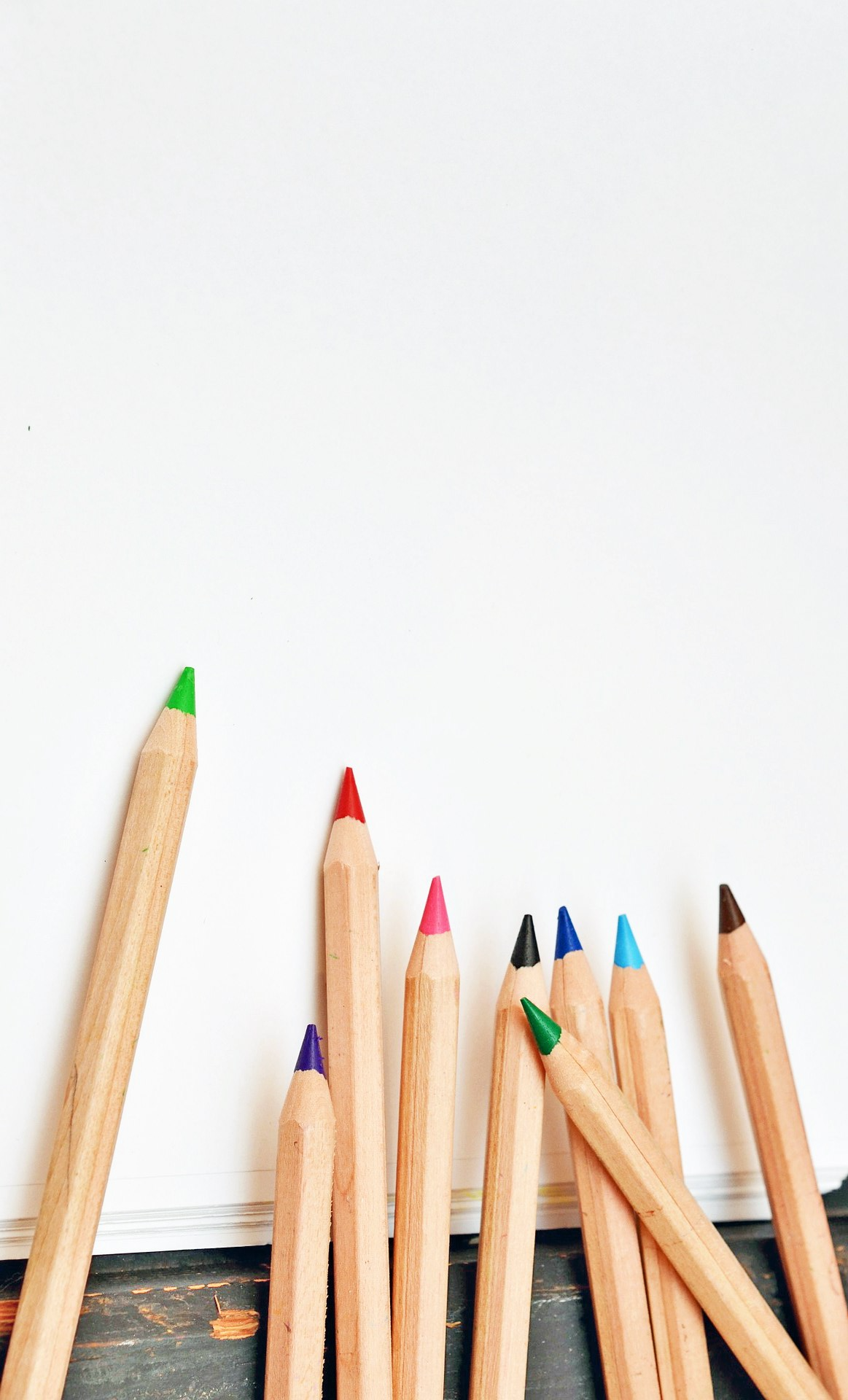 Image of a blank piece of paper with colored pencils.